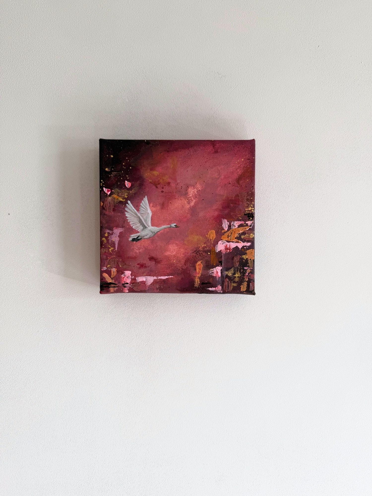 Het zwaanschilderij aan een lichte muur.