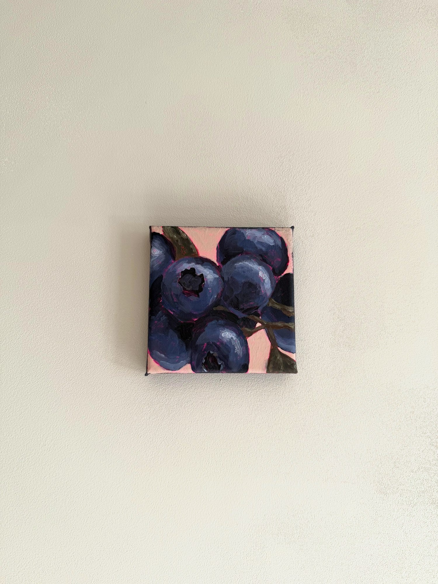 Het bessenschilderij aan een lichte muur.